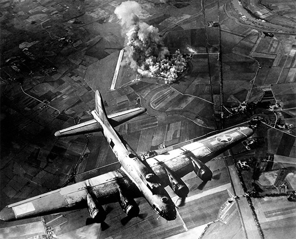 black and white photo of a war plane with a fire underneath it